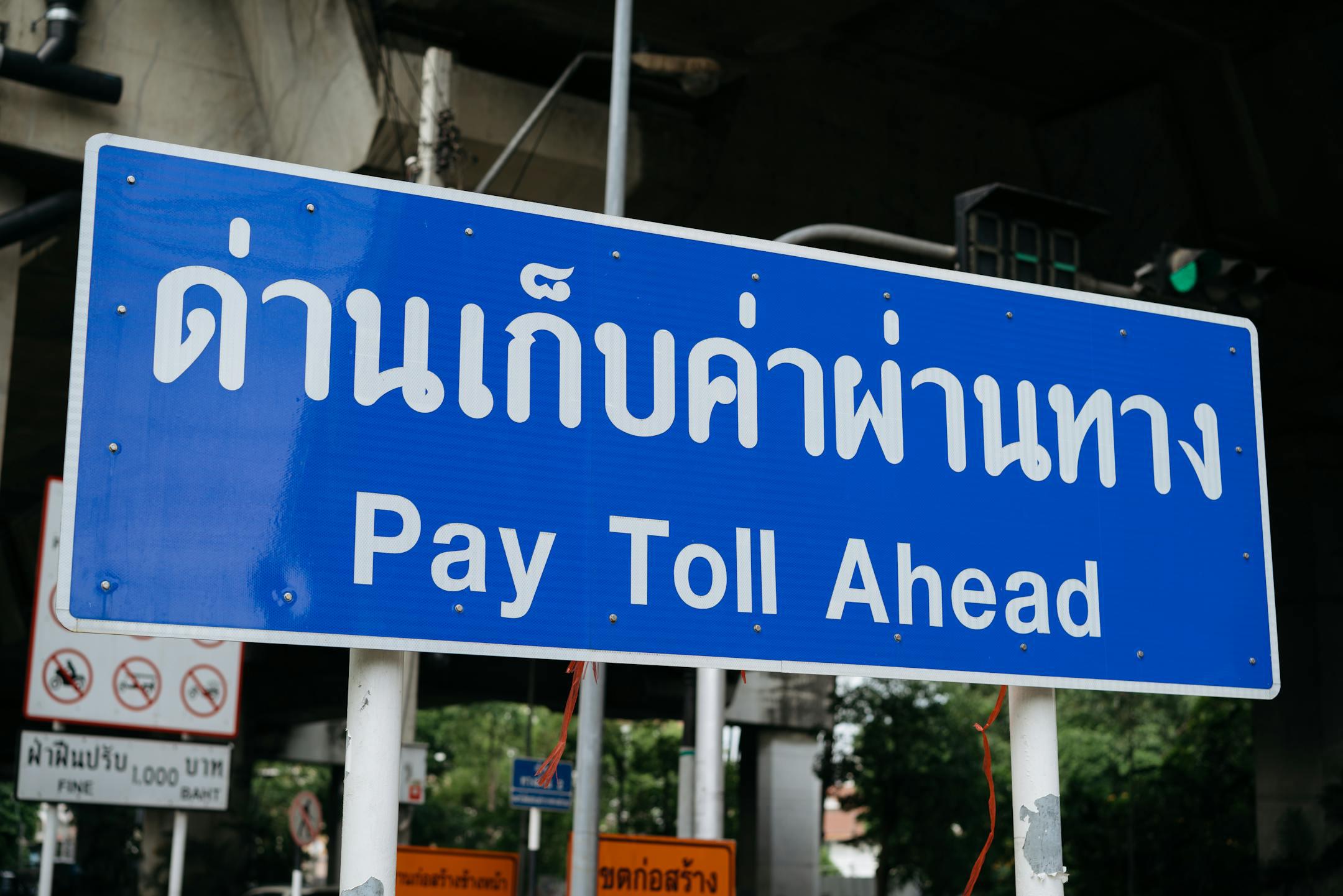 Blue sign indicating a toll road ahead, located in Bangkok, Thailand.