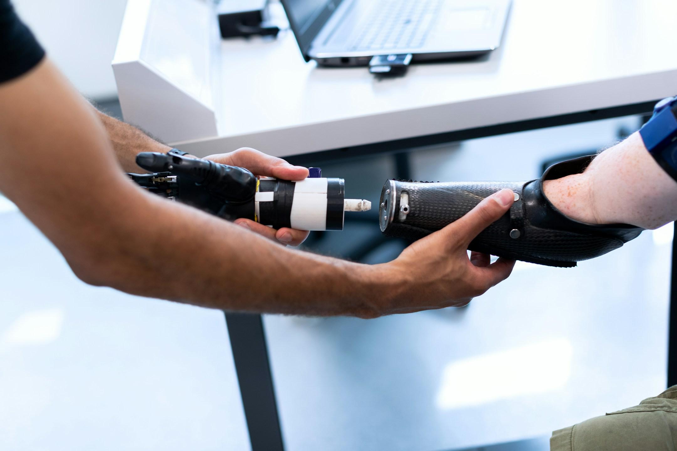Male mechanical engineer attaches prosthetic arm