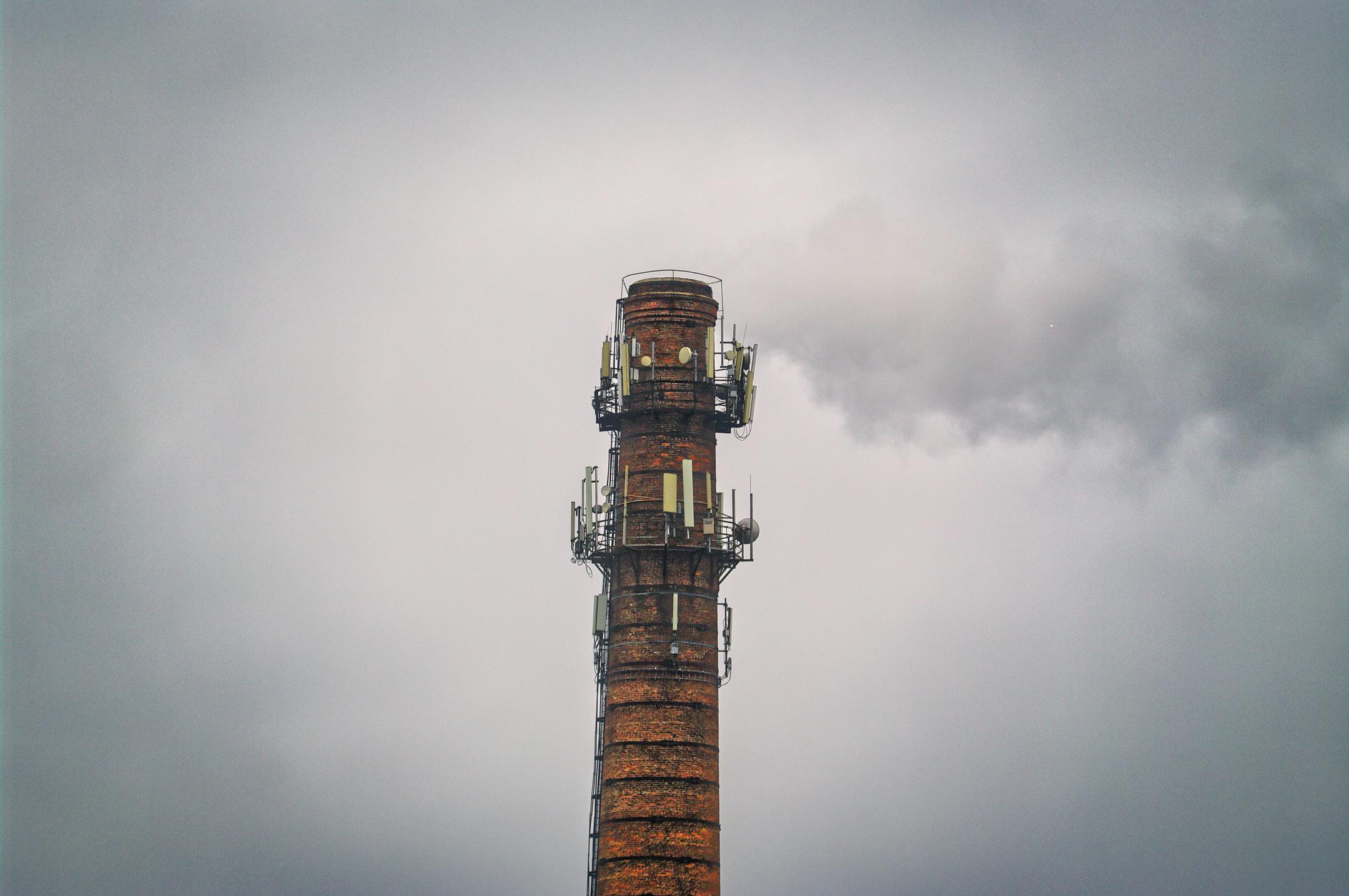 Old red brick industrial smokestack with satellite dishes