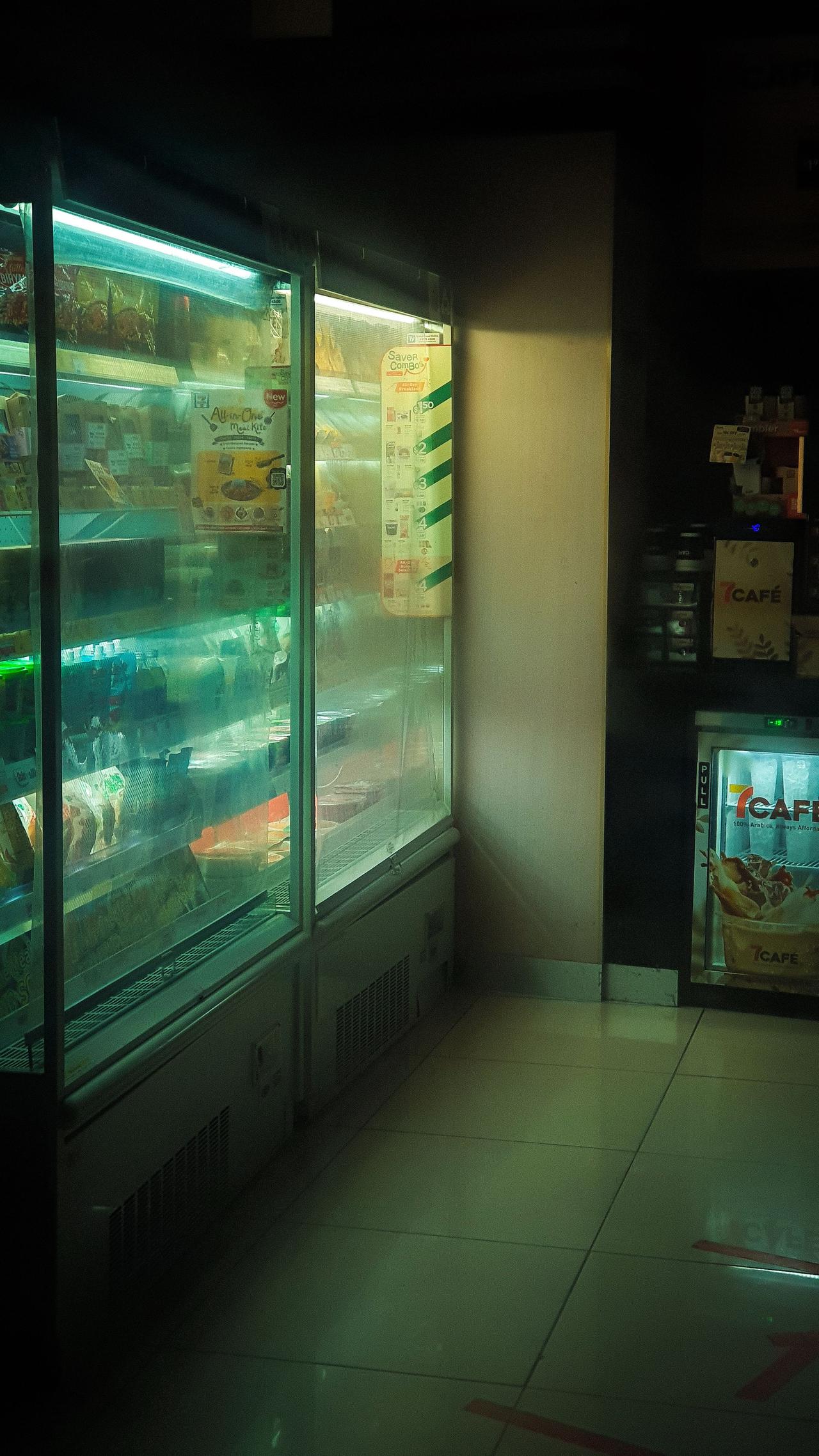 Chilled display in a Singapore store with illuminated beverages and snacks in the cooler.