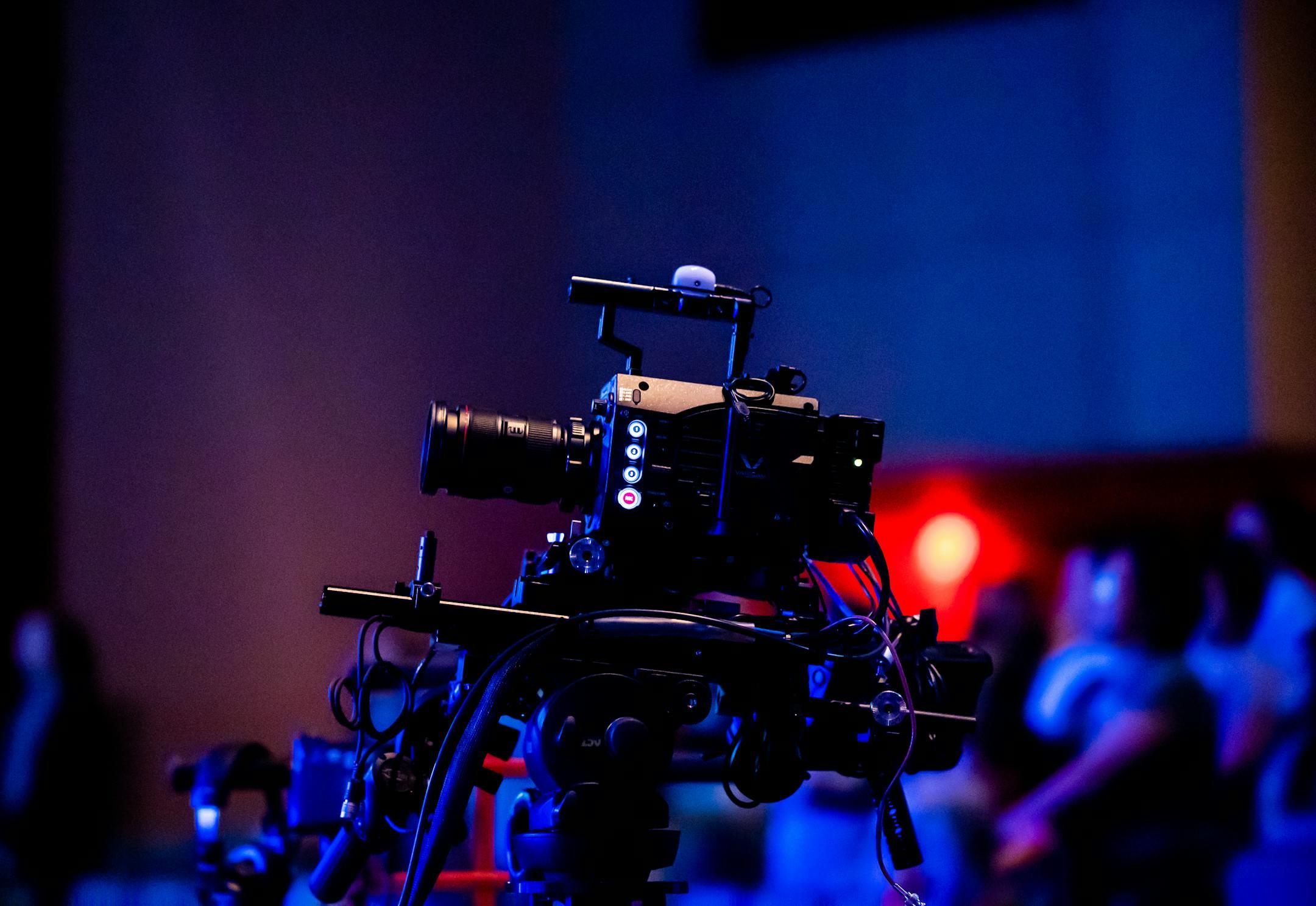 A high-quality camera setup capturing a live studio event with an audience in the background.