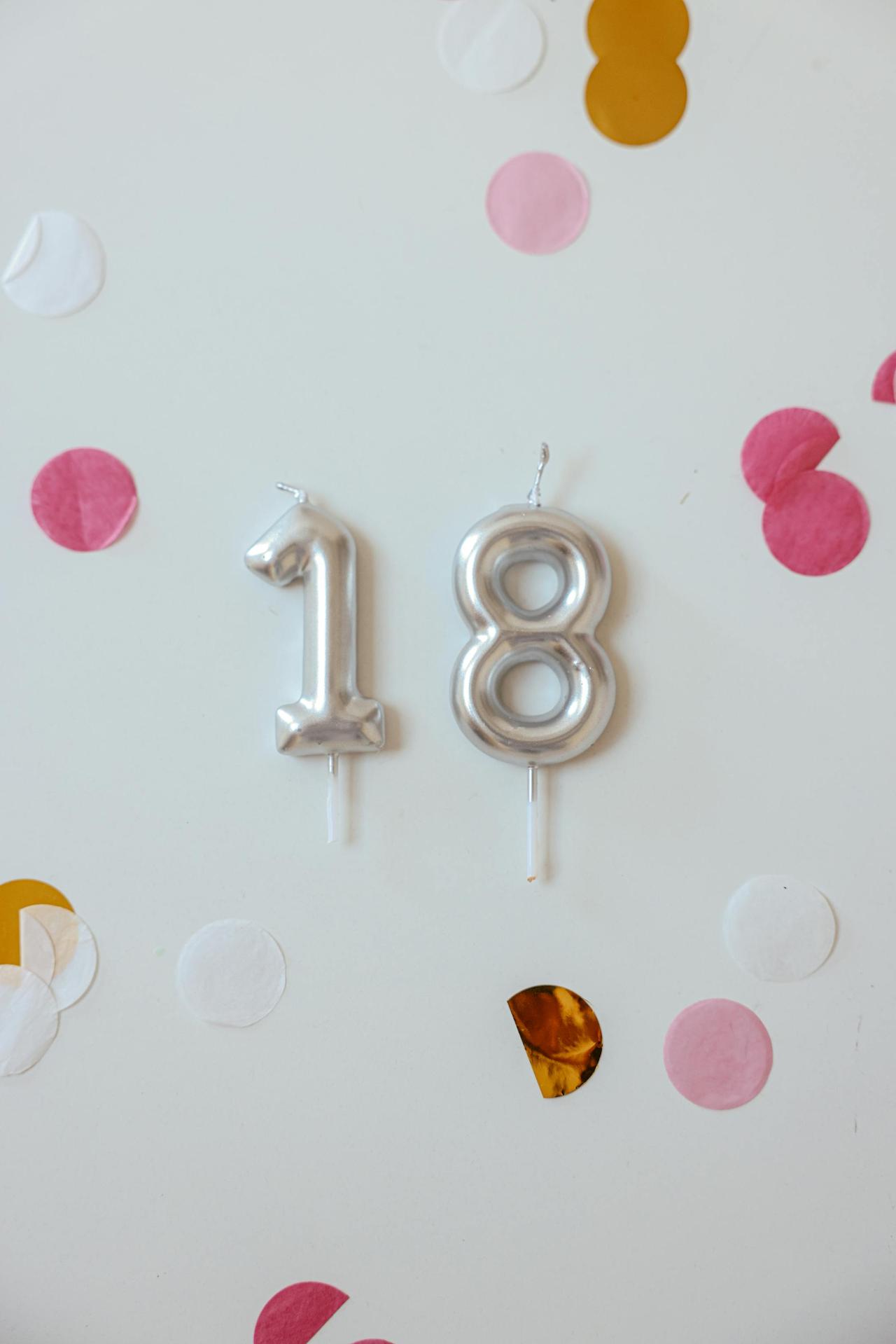 Festive decor with silver number candles on a white background, ideal for 18th birthday celebrations.