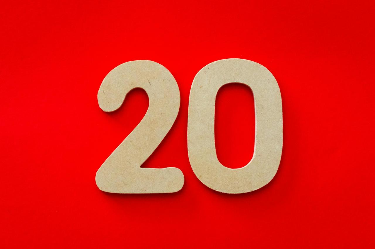 Wooden number 20 on vibrant red background, perfect for design themes.