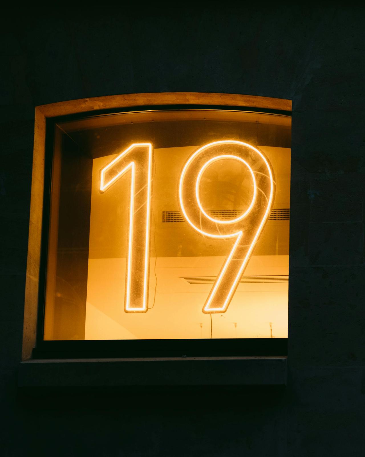 Close-up of a neon number 19 in a window display with a warm glow.