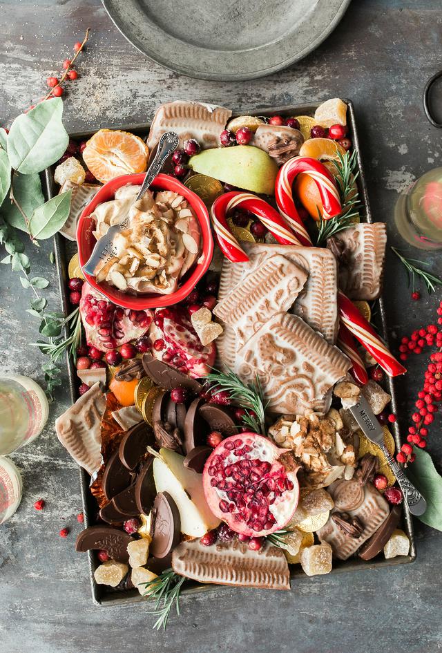 A plate filled with traditional Christmas treats. Gingerbread, candy canes and merry wishes galore.