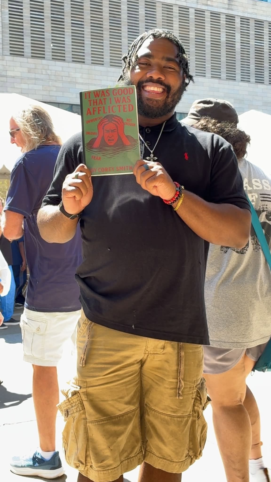Corey Smith holding his published book