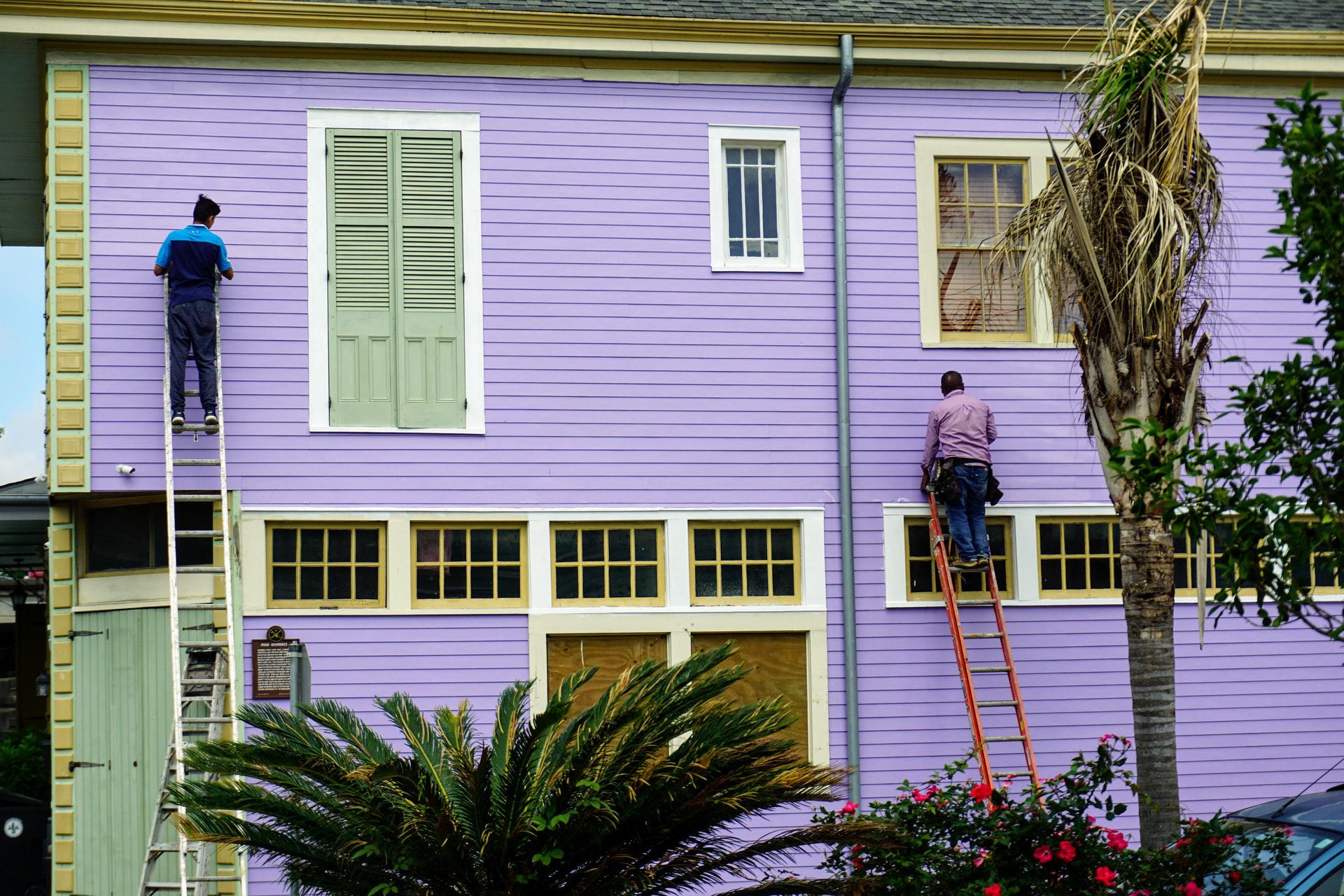 Image of painters working on the outside of a lilac colored home exterior