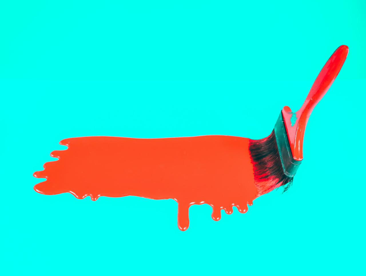 Painting a red strip across a blue backdrop.