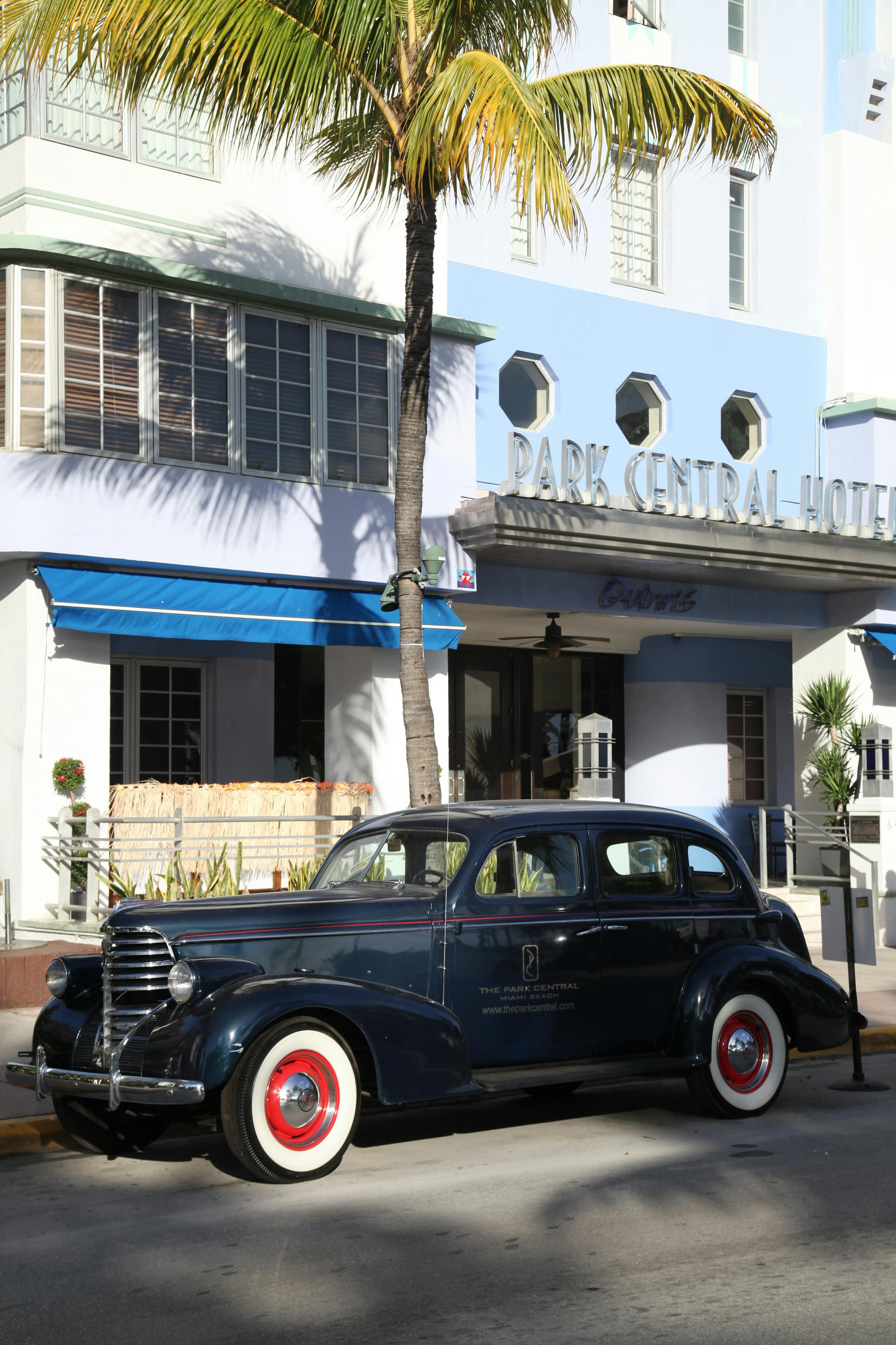 Classic vintage car parked outside Park Central Hotel in Miami's Art Deco District.