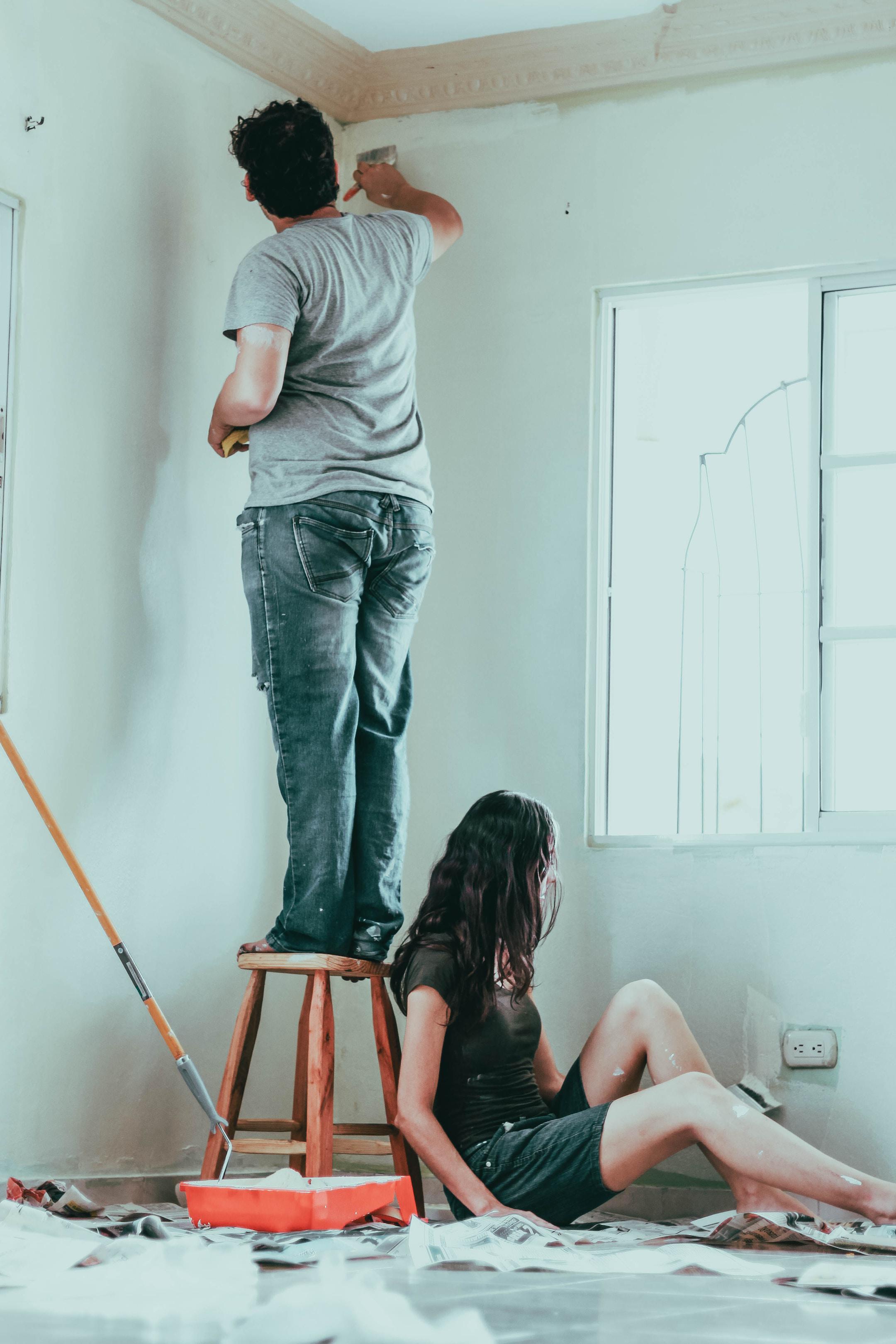 Pareja pintando su nuevo hogar.