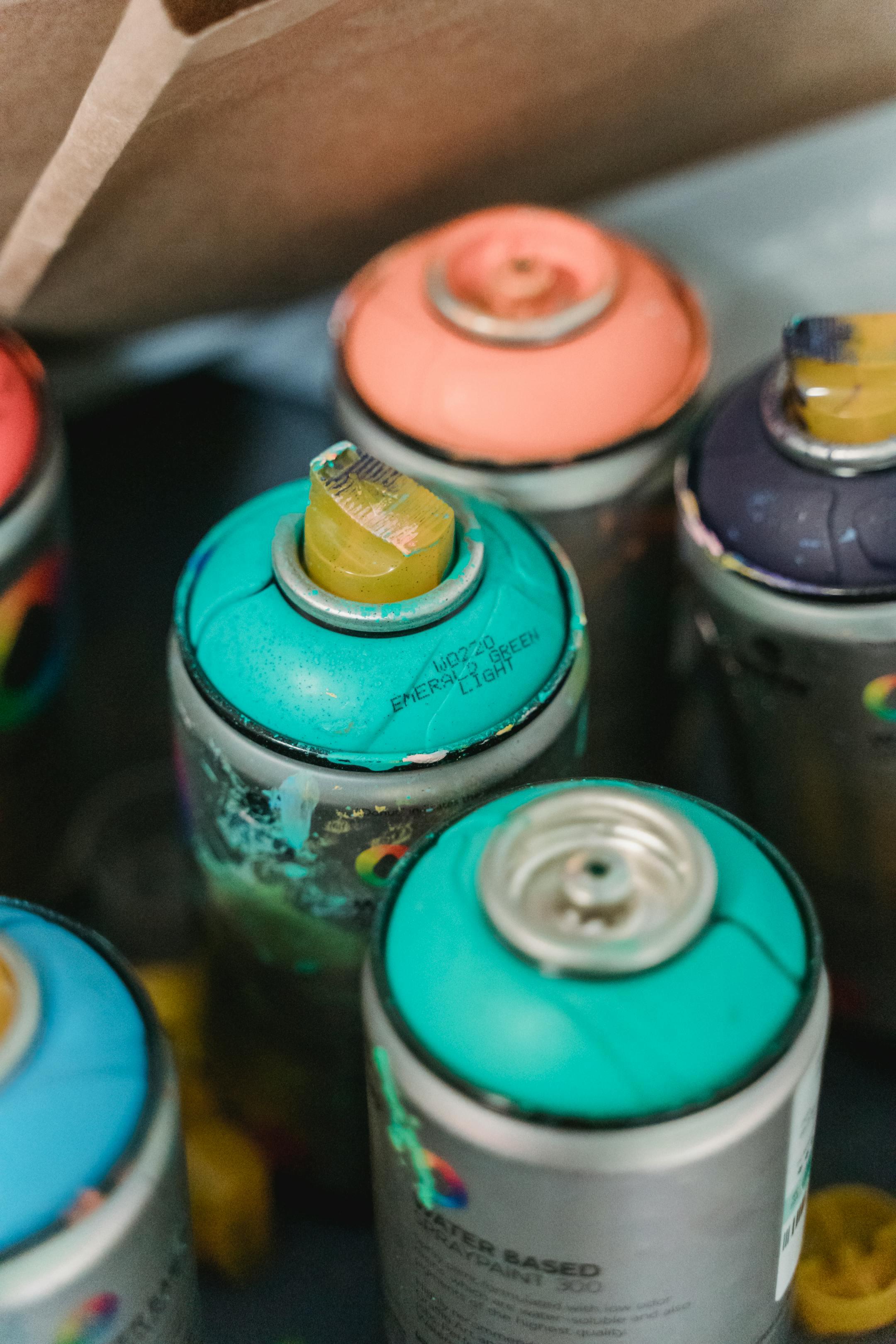 Close-up view of vibrant spray paint cans showcasing various colors and textures.