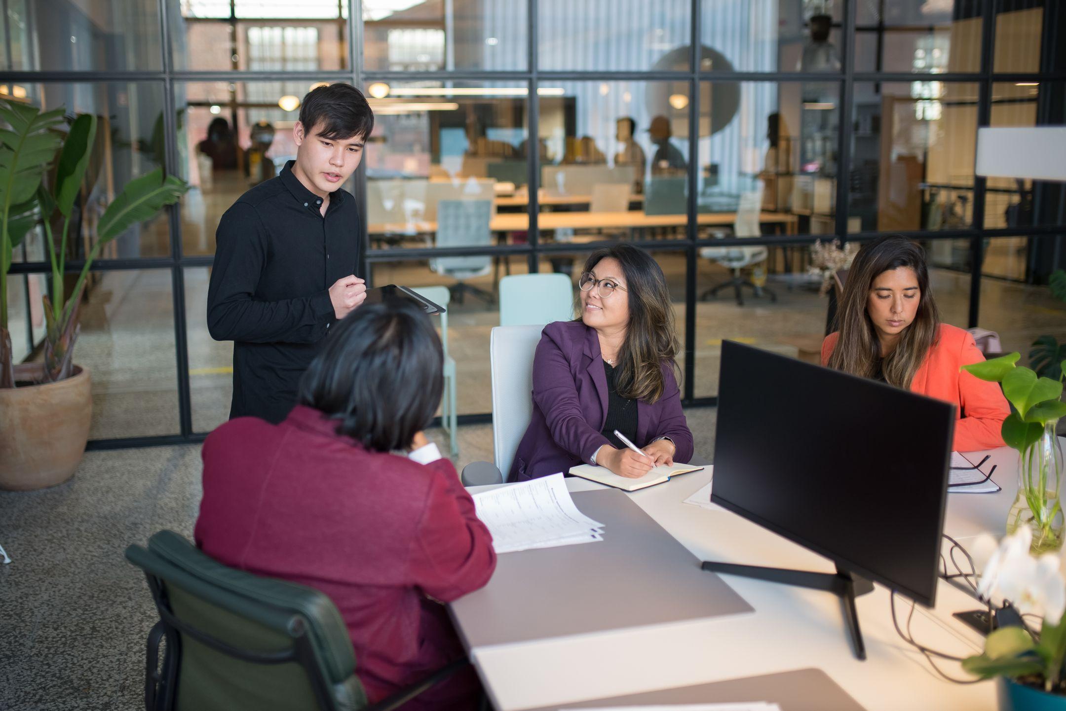 Colleagues engage in a meeting within a modern office, promoting teamwork and productivity.