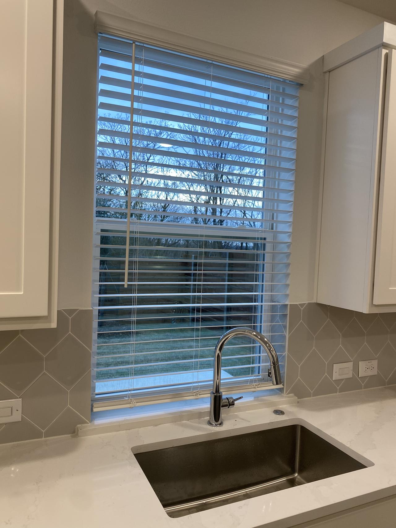 Open blinds over a sink.