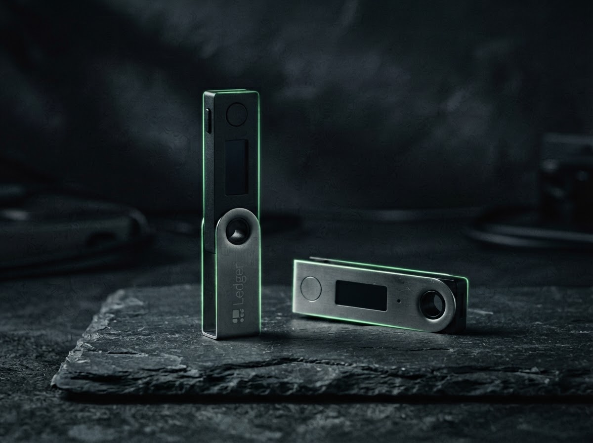 Two compact black hardware wallets arranged on a dark surface