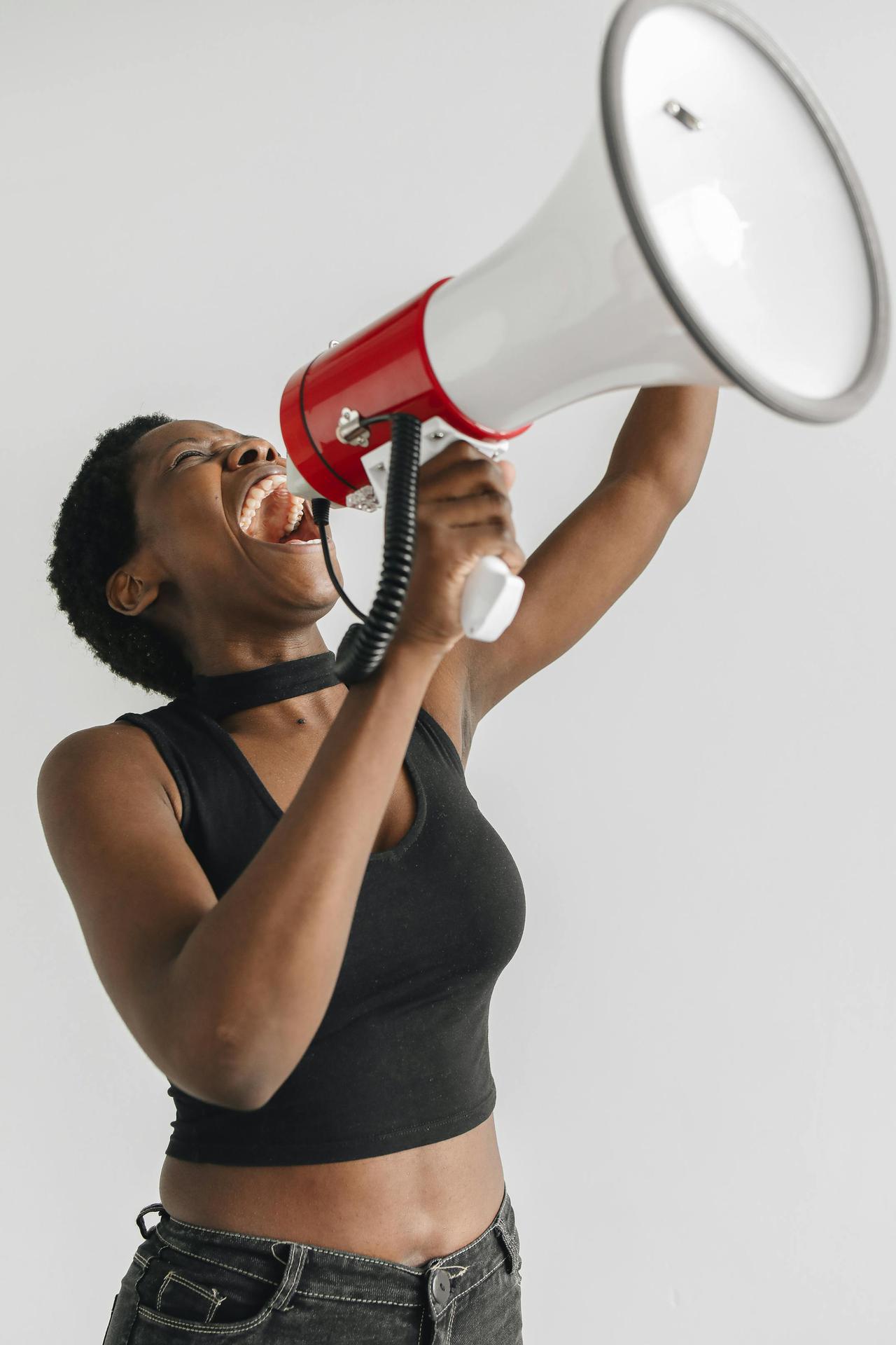 A passionate woman raising her voice through a megaphone in protest.