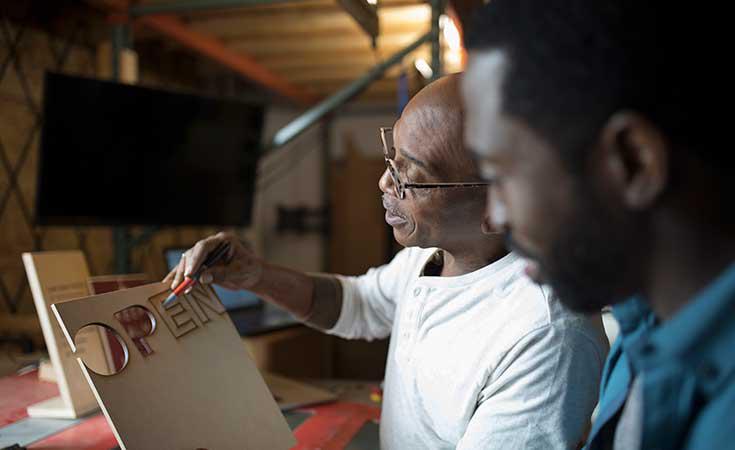 two people working on an open sign