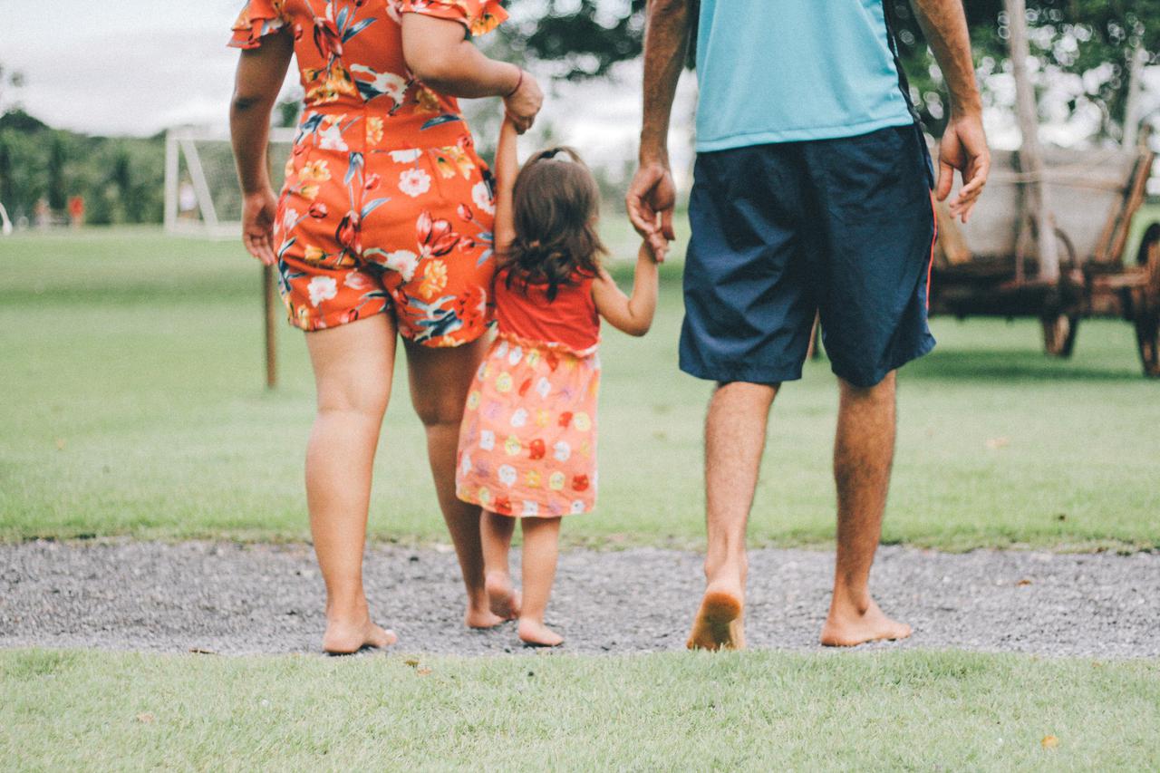 mom and dad with child in the middle holding hands