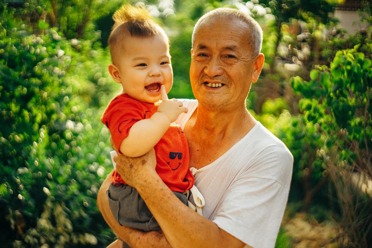 elderly man holding a young child