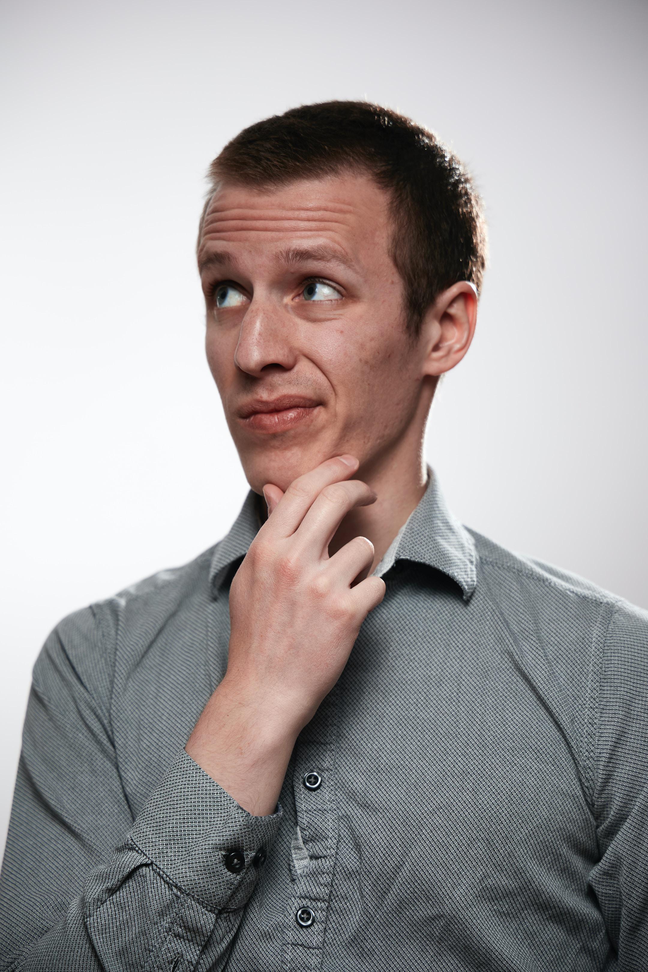 Portrait of a curious man in clean clothes on a white background.
