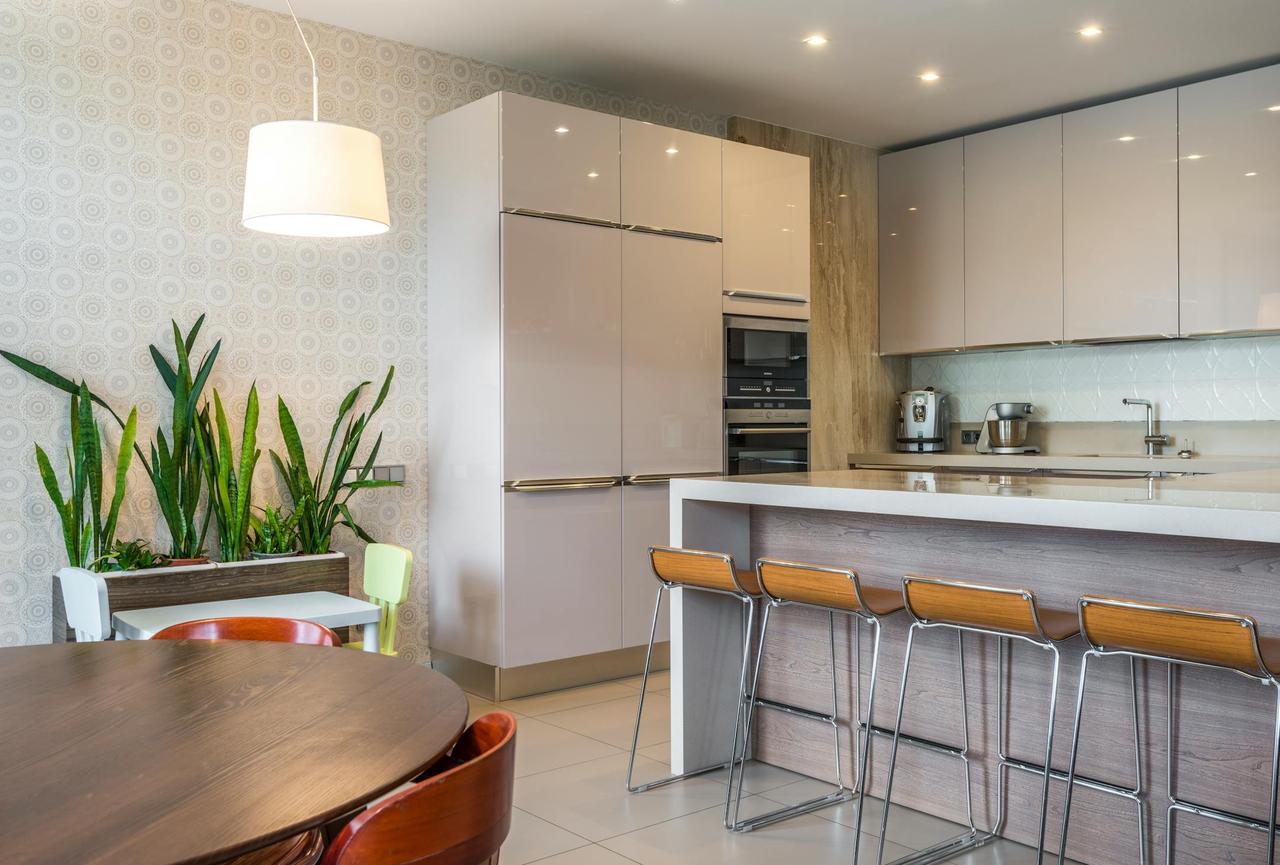 Contemporary kitchen interior featuring stylish decor, potted plants, and modern appliances.