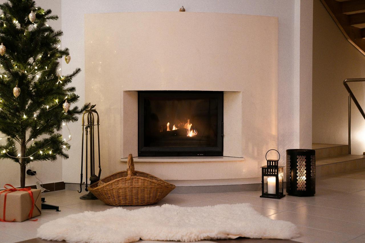 Warm Christmas atmosphere in a living room with a decorated tree and a glowing fireplace.