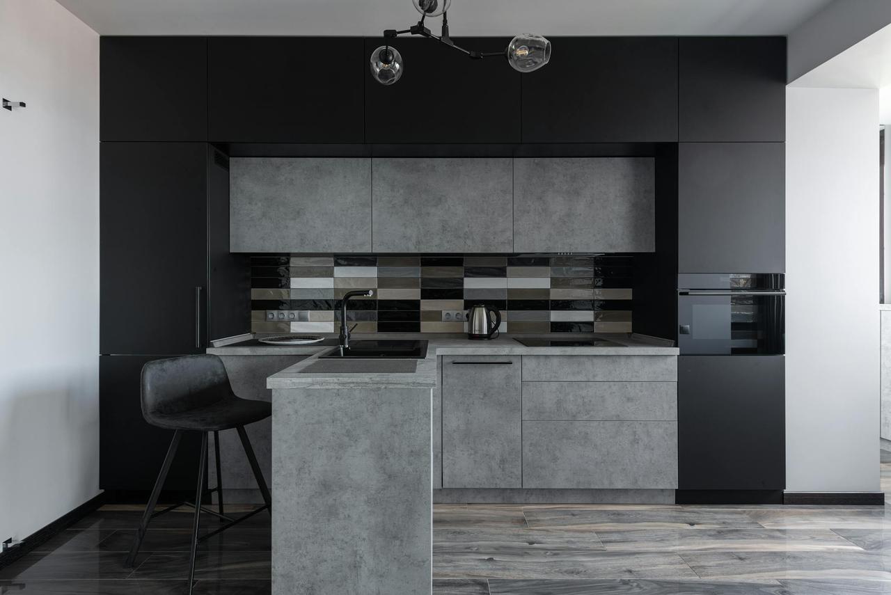 Sleek modern kitchen with black and gray cabinetry, perfect for minimalist decor.