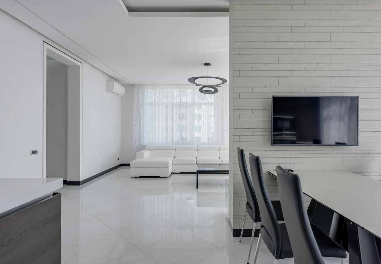 Spacious, contemporary open-plan apartment lounge and dining area with minimalist decor.