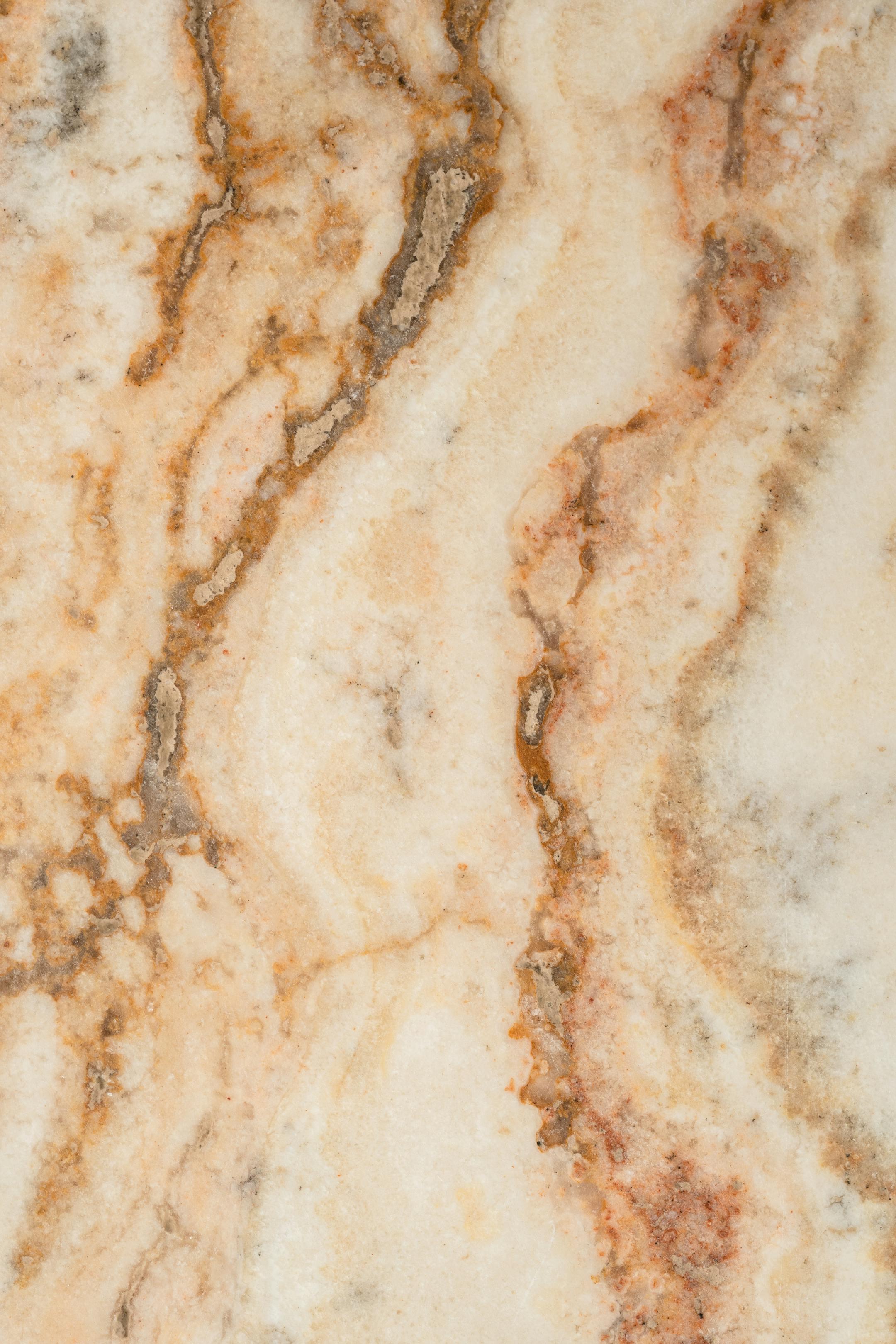 Close-up view of a beige and brown marble texture showcasing natural patterns.
