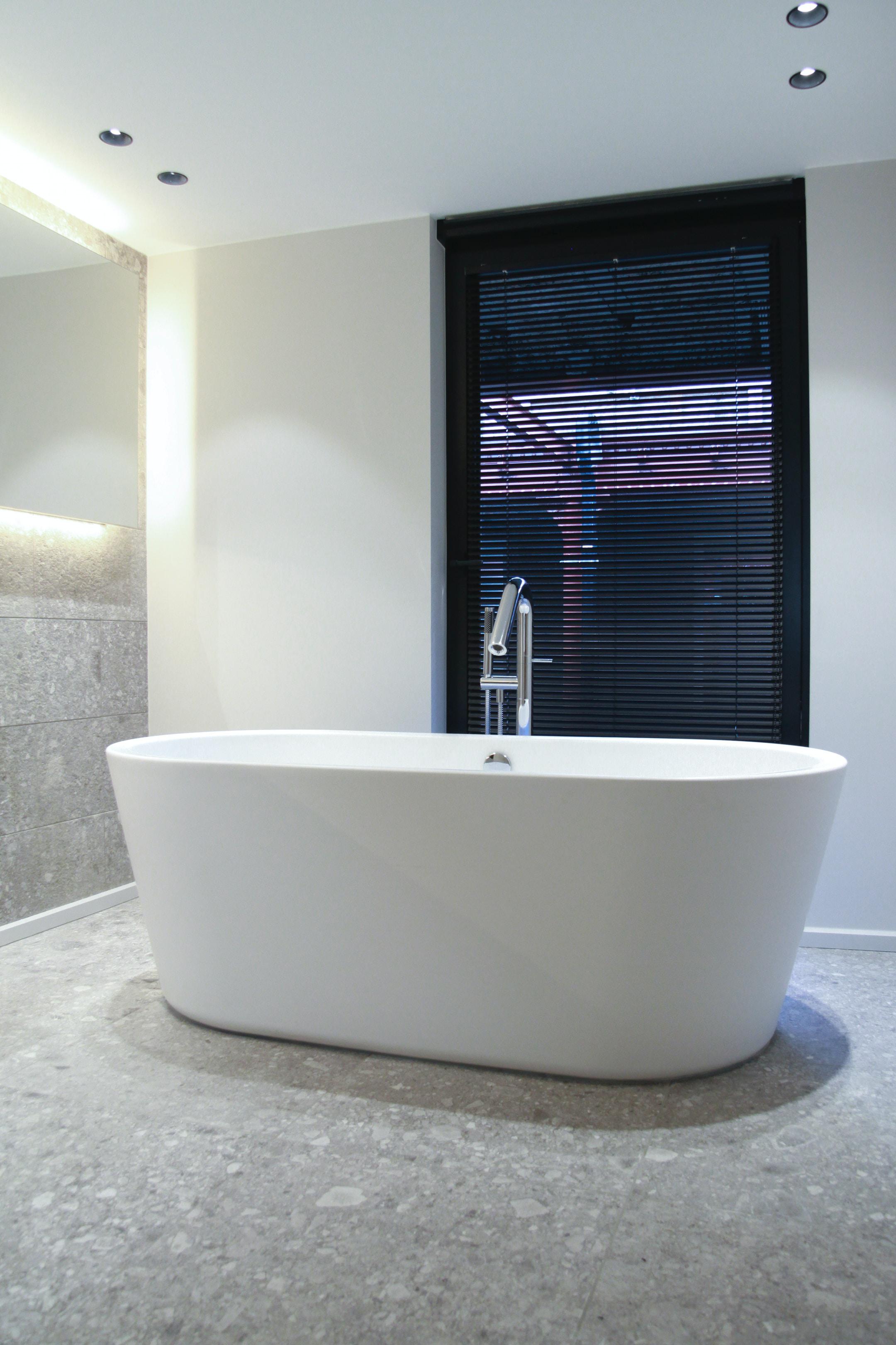 An image of a bathtub in a modern bathroom.
