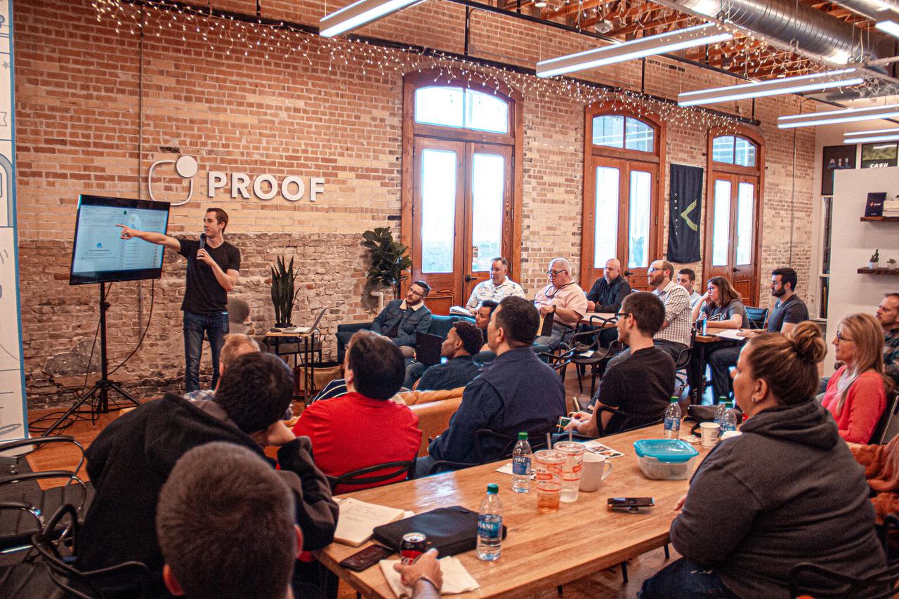 Man presenting power point to small audience in start-up office. 