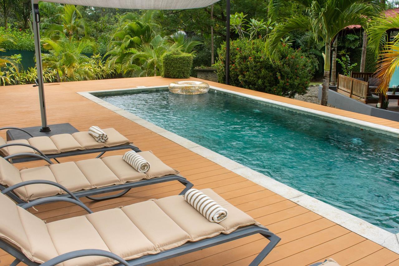 Relax by the outdoor pool with elegant deck chairs and lush greenery.