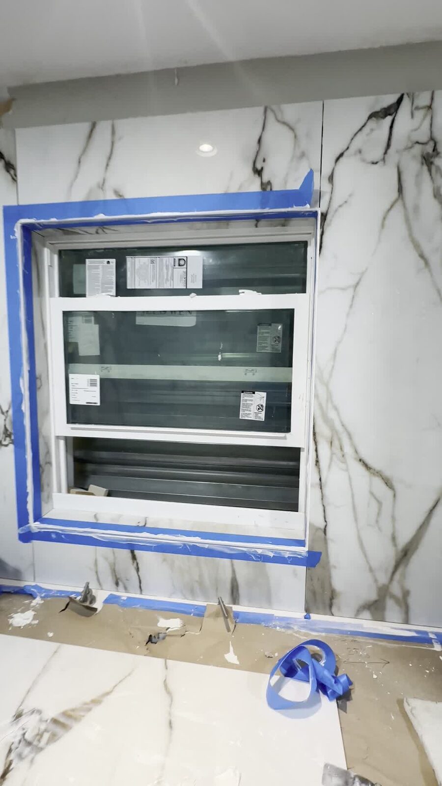 The mitered tile edge around this kitchen window — tile cut to 45 degrees, two faces meeting in a seamless corner with no metal trim