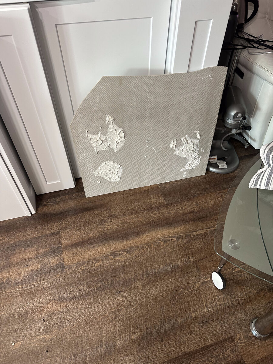 Before: Large-format tile failing due to spot-bonded mastic with only 4-5 adhesive globs showing less than 20% coverage