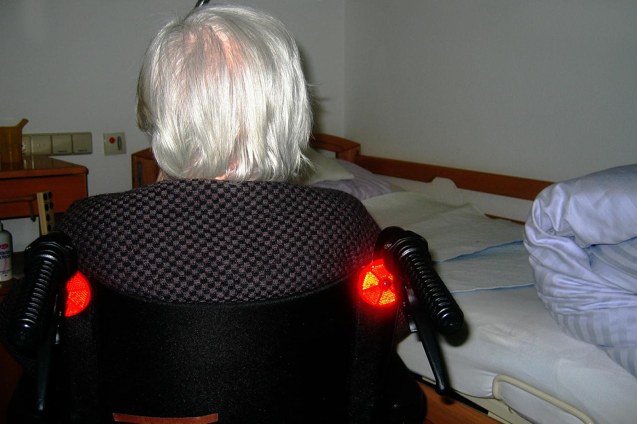 Elderly woman with white hair sitting in a wheelchair