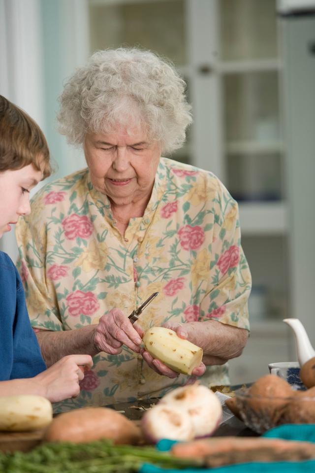 an elderly woman showing her grandson how to peel potatoes at a senior day care center in Dayton, Ohio