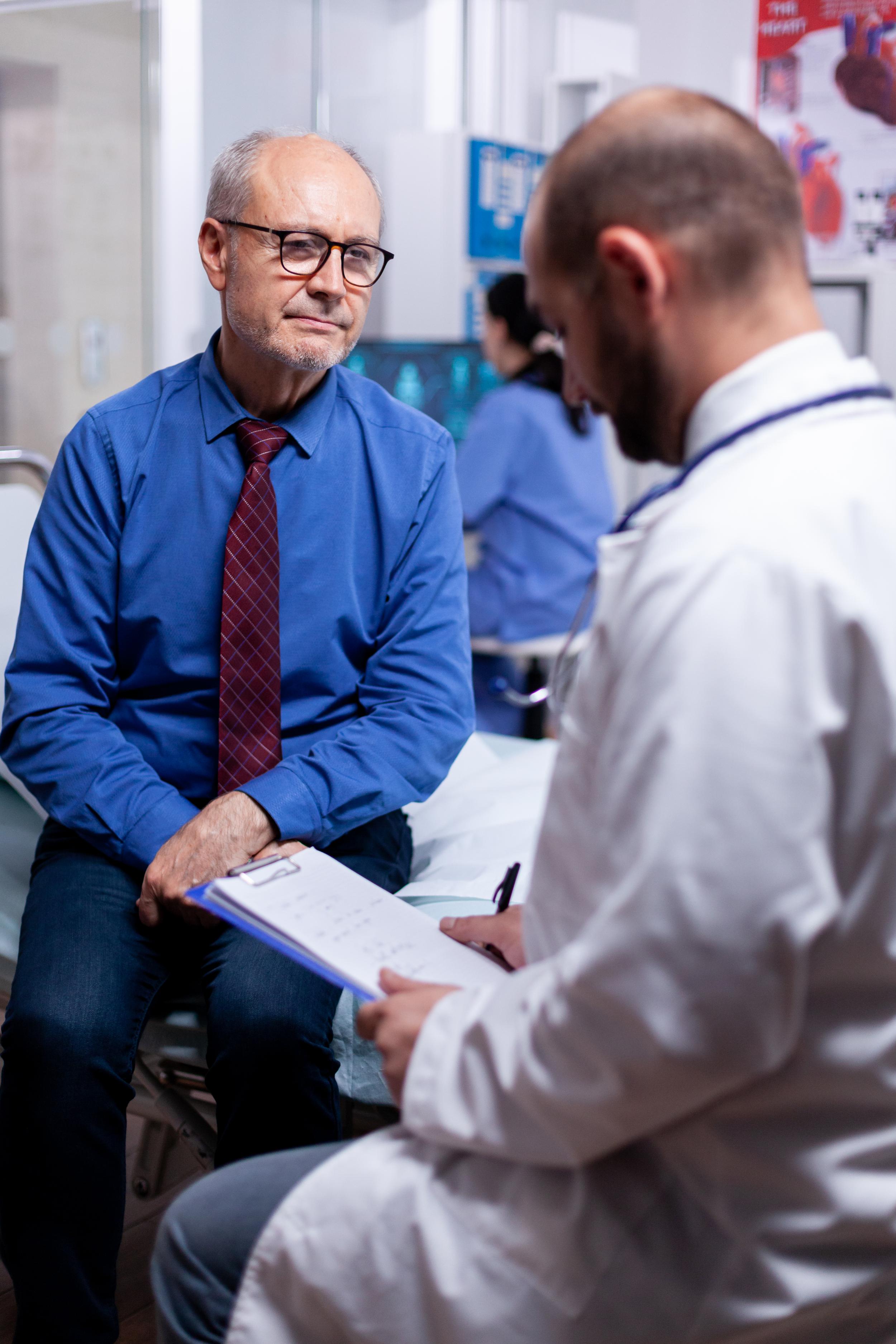 old-man-answering-doctor-questionnaire-examination-hospital-room.jpg