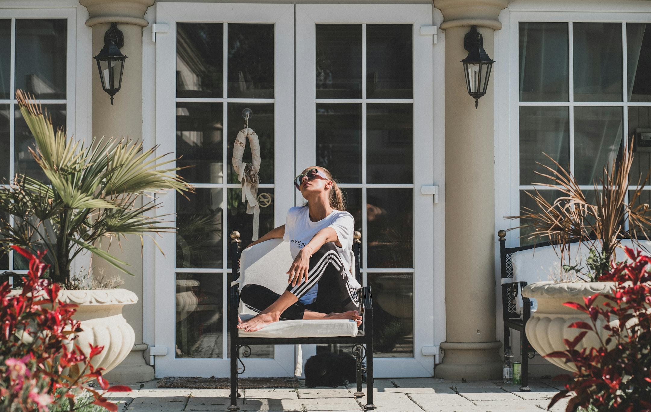A woman sitting on a porch made by a landscape design and build company