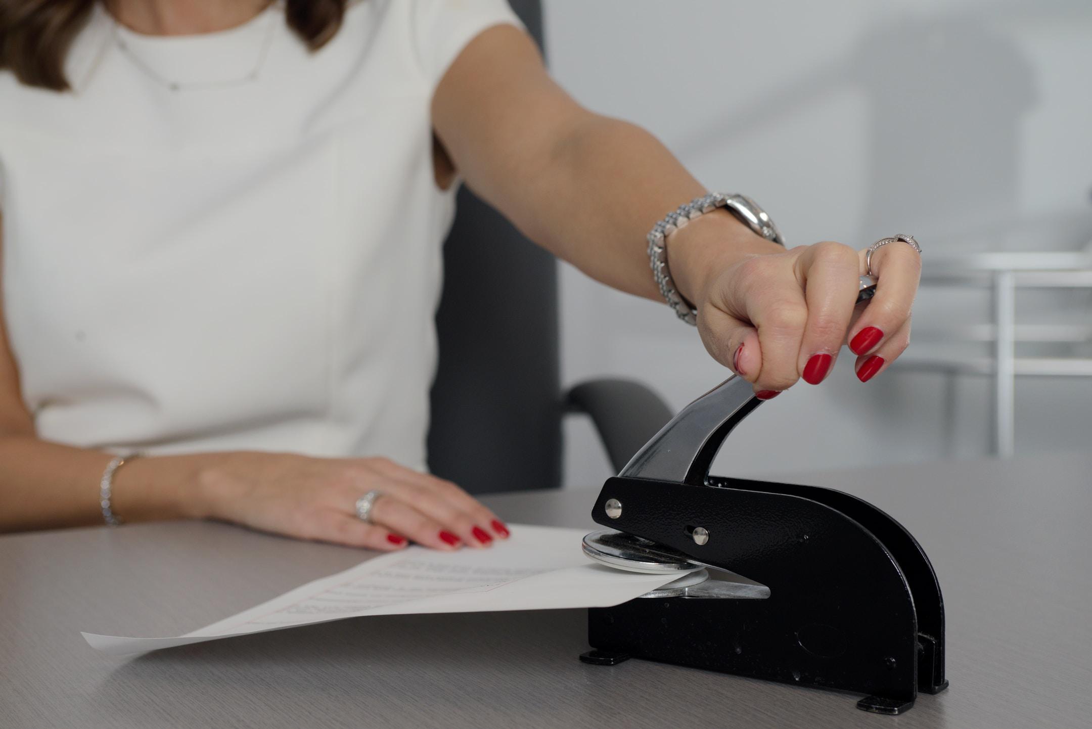 A health insurance broker in Georgia stapling a piece of paper