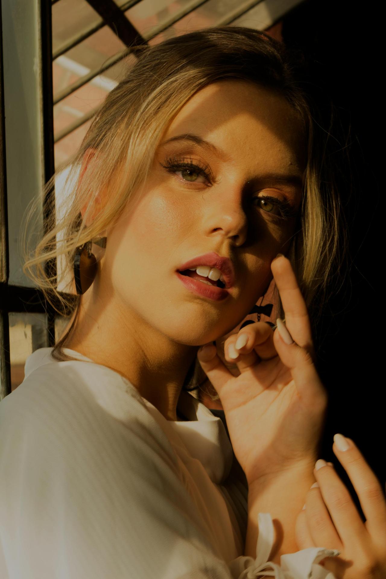 Striking portrait of a young woman with dramatic lighting and makeup indoors.
