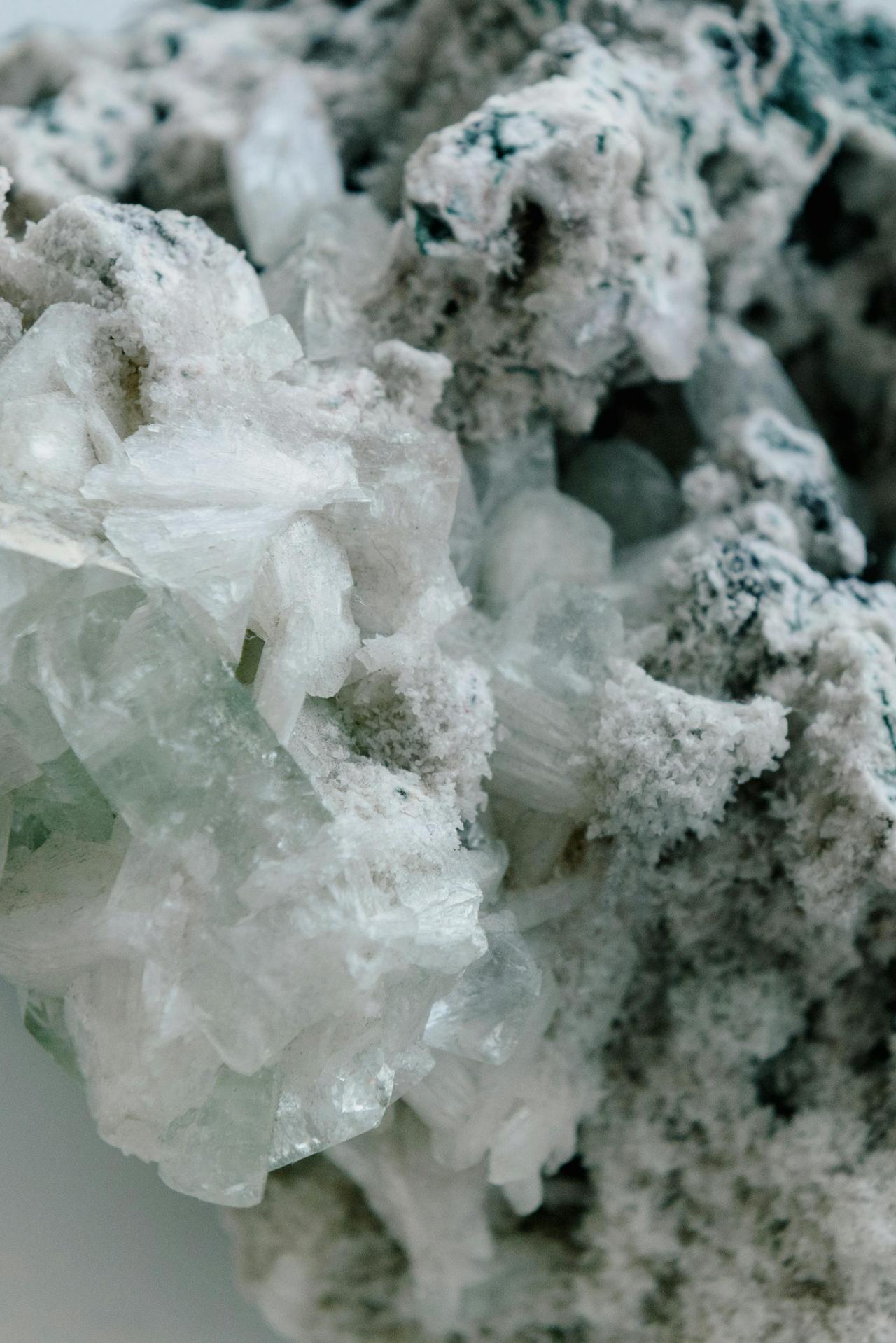 Detailed macro image highlighting white frosty mineral crystals on a rock surface.