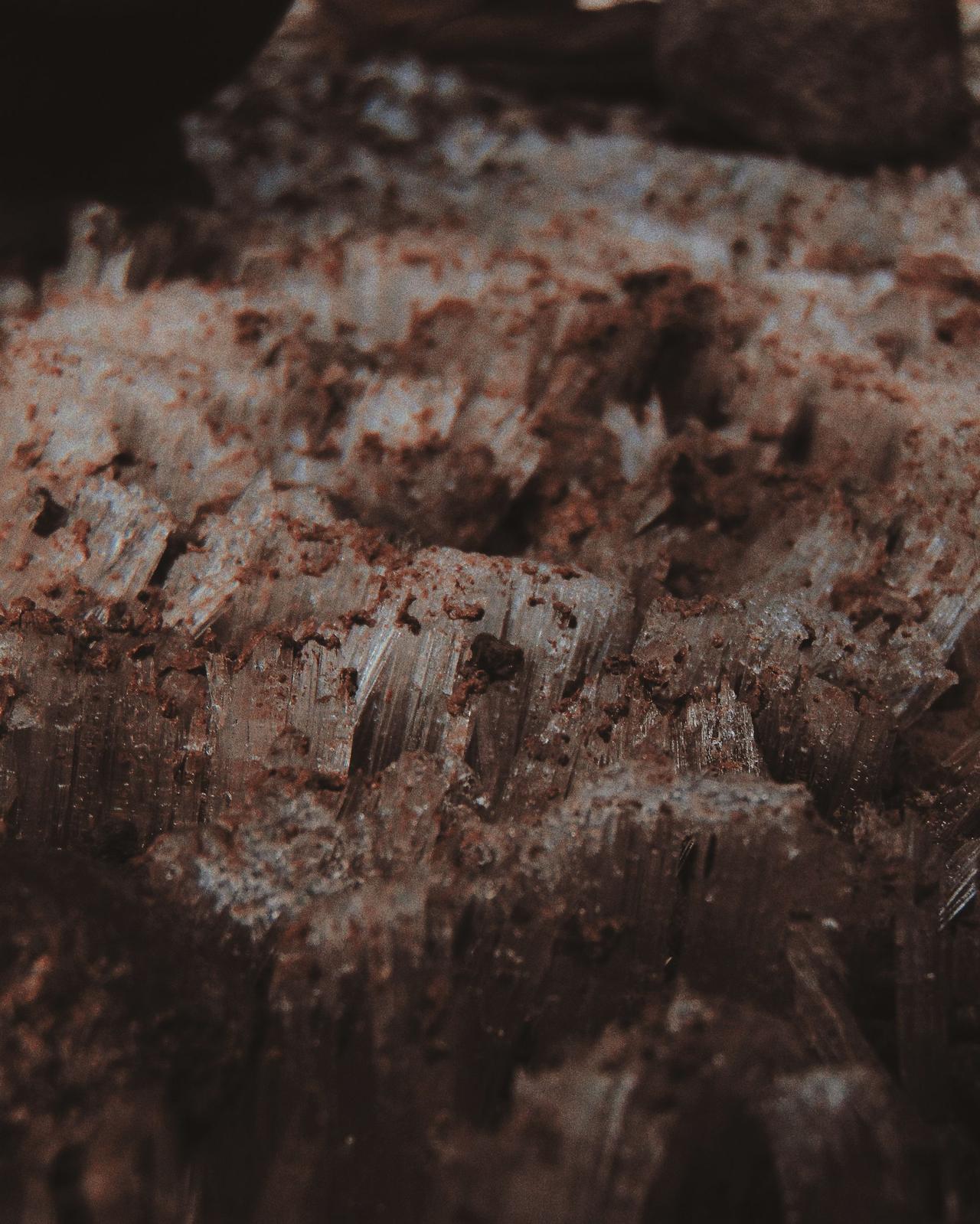 Detailed close-up of rugged geode surfaces surrounded by earthy soil texture