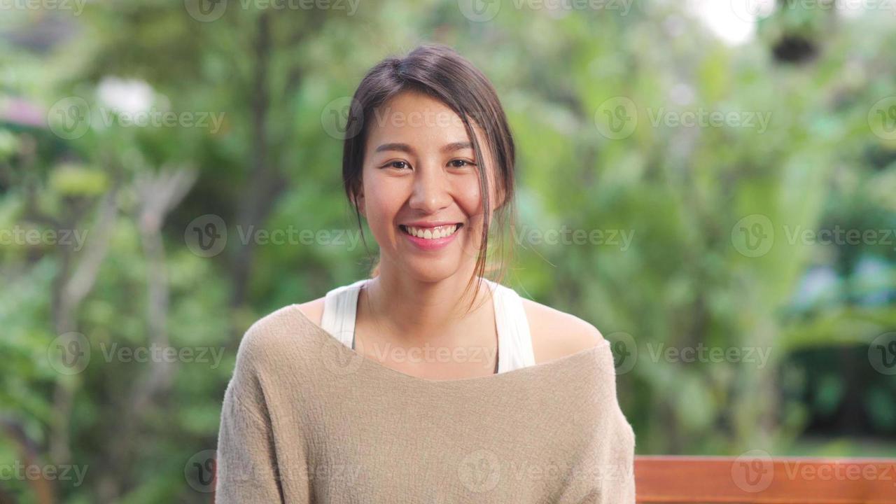 asian-woman-feeling-happy-smiling-and-looking-to-camera-while-relax-on-table-in-garden-at-home-in-the-morning-lifestyle-women-relax-at-home-concept-photo.jpg