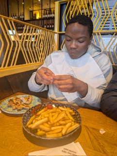 Young person developing life skills through real-life experience like eating out