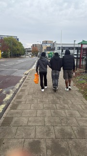 Young person confidently walking with support in the community