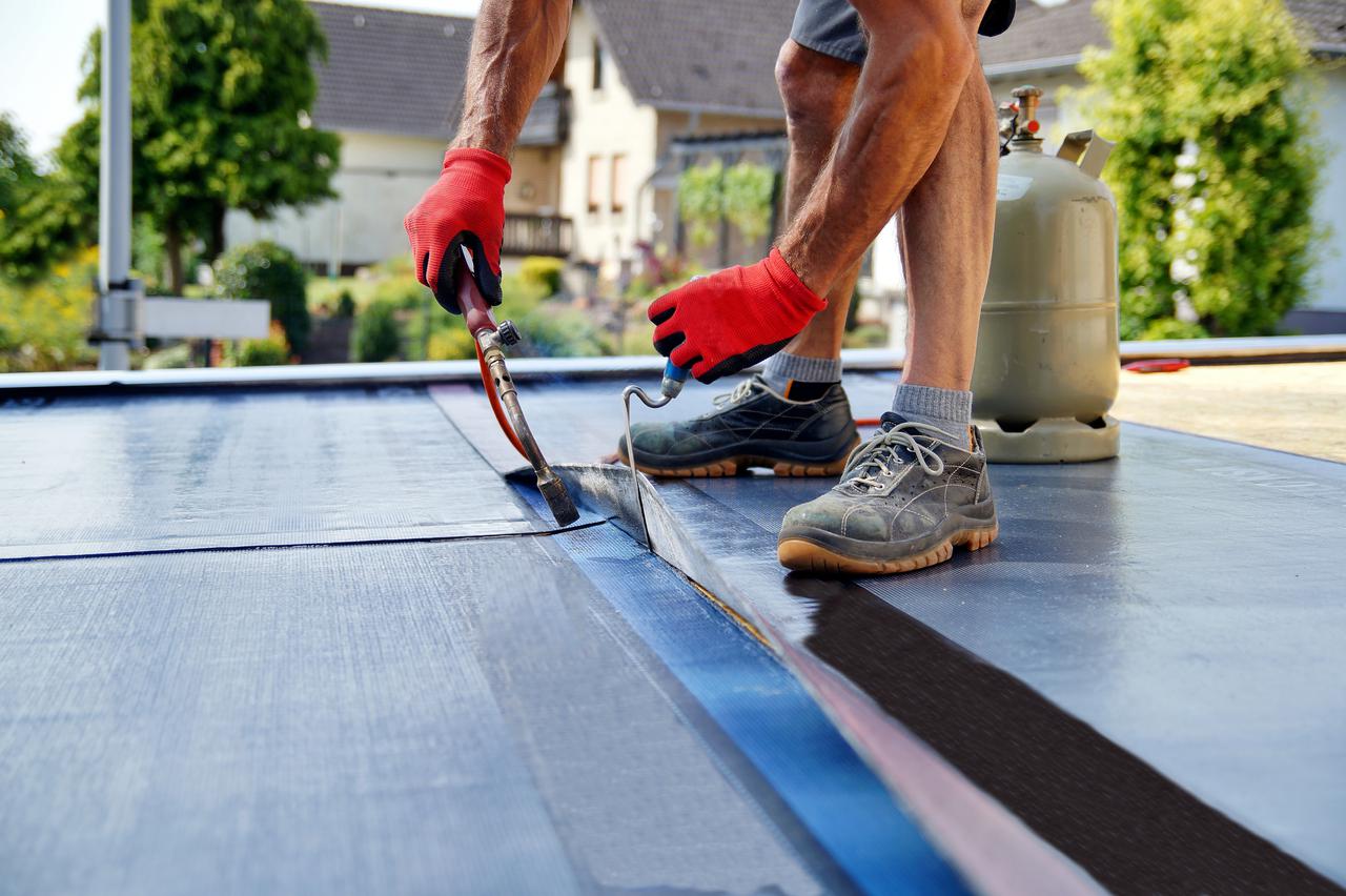 flat-roof-installation-with-propane-blowtorch-during-construction-works-with-roofing-felt.-heating-and-melting-bitumen-roofing-felt.-1171112097_3872x2578.jpeg