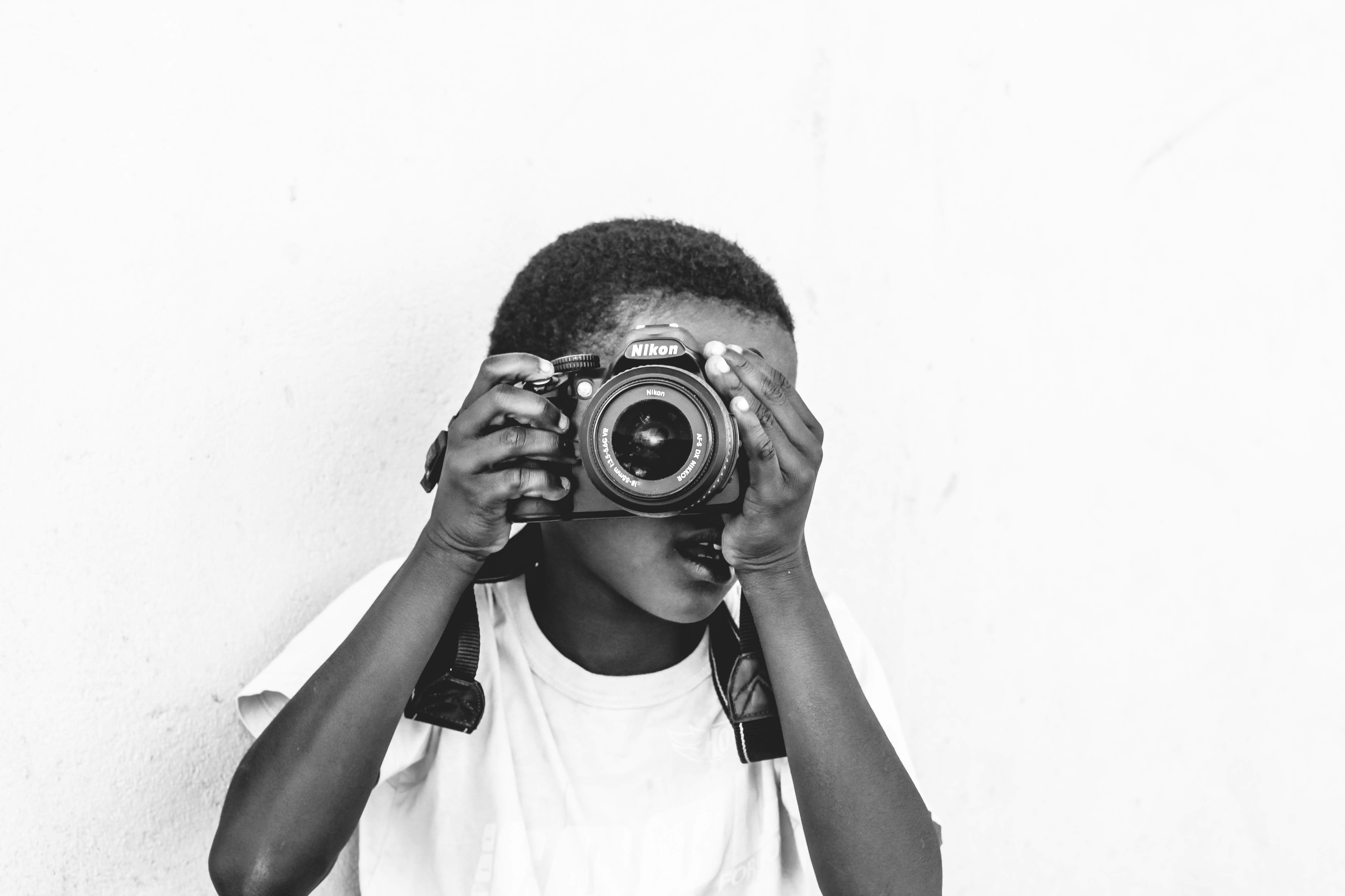 Young person holding a camera, learning photography
