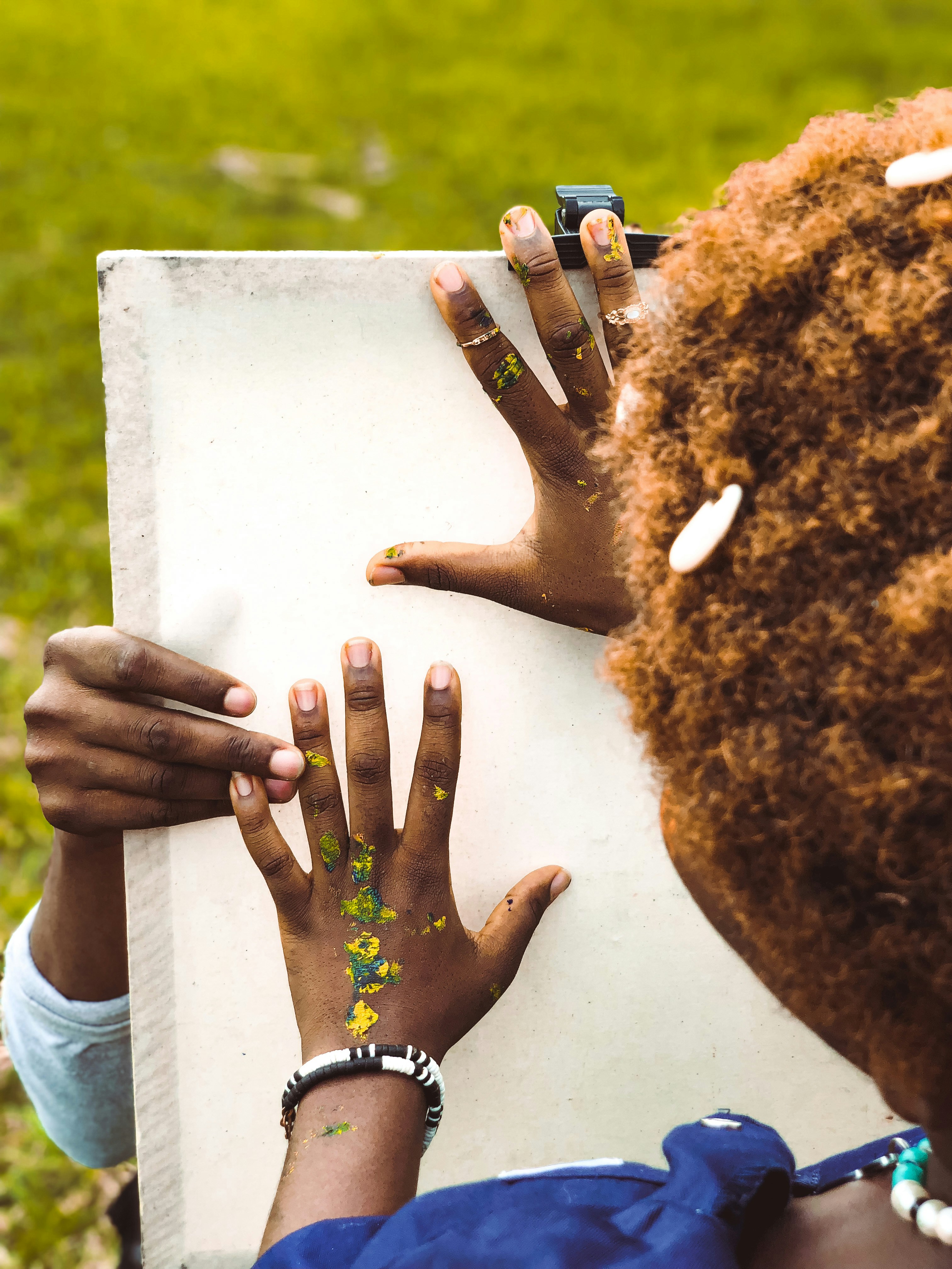 Group of hands holding a piece of paper together in collaboration