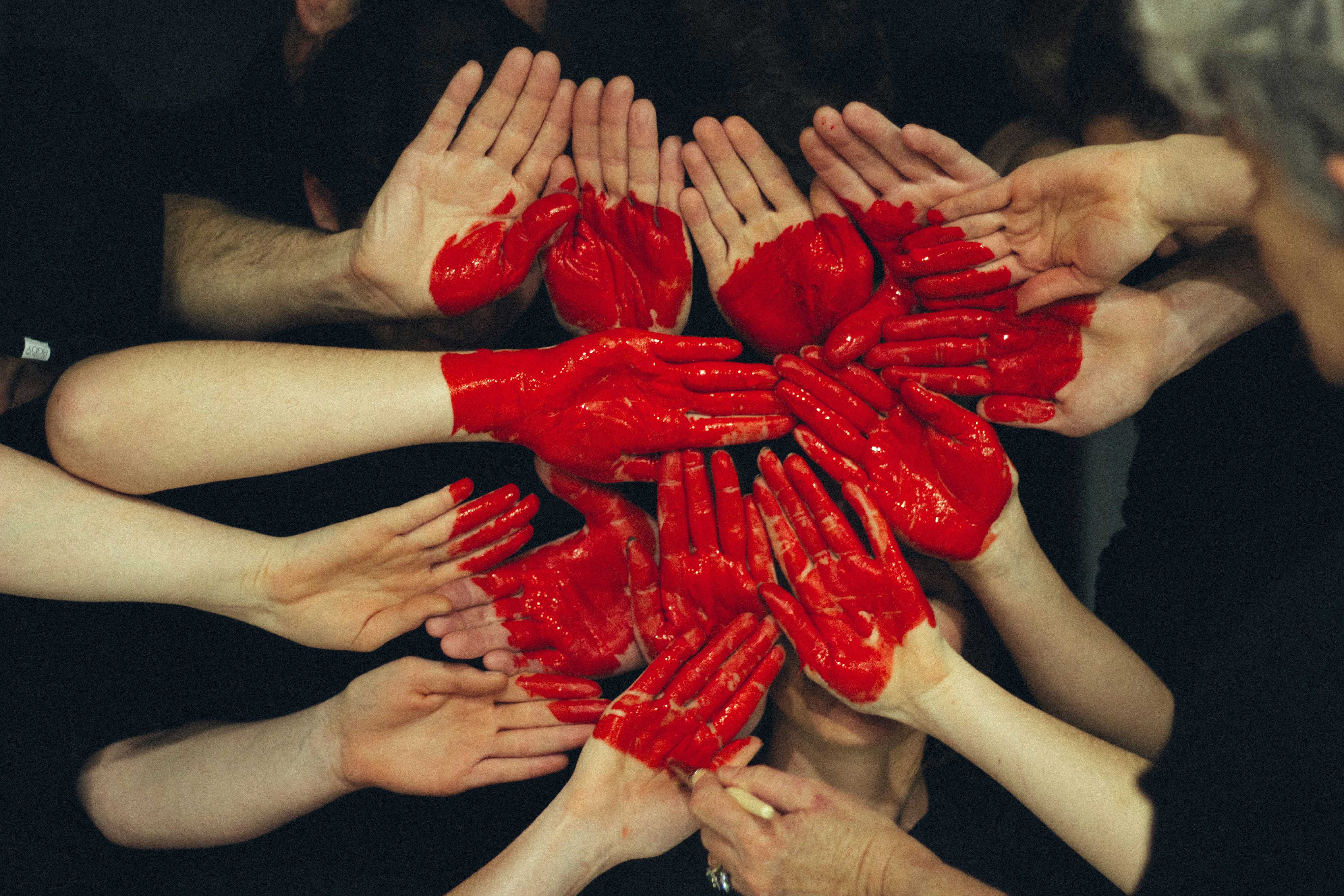 Hands formed together with red heart paint
