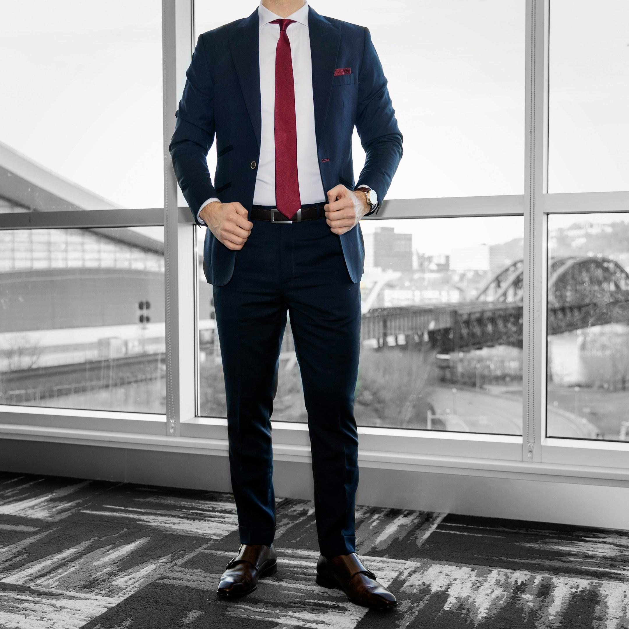 Dapper Professional wearing a custom navy blue blazer, a red tie and pocket square and a pair of brown double monk dress shoes.