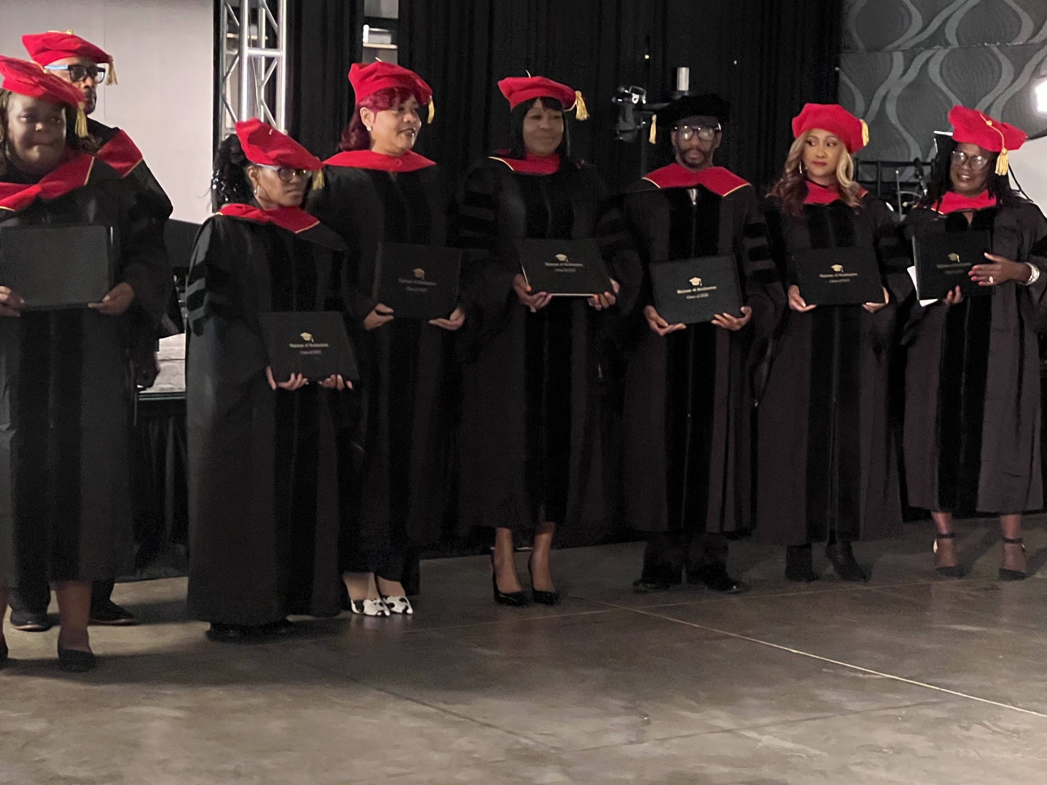 Graduates in academic regalia celebrating at commencement ceremony with caps and gowns